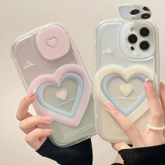 Two people holding up a heart-shaped phone case in pink and blue.