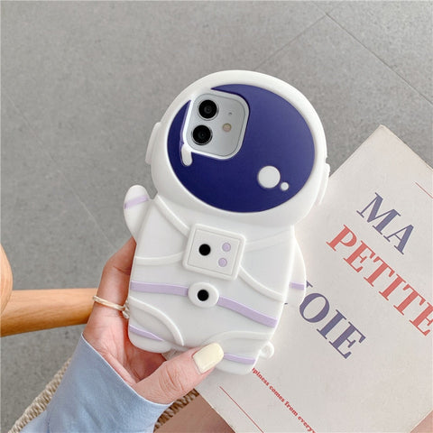 A hand holding an iPhone case with an astronaut design on the back