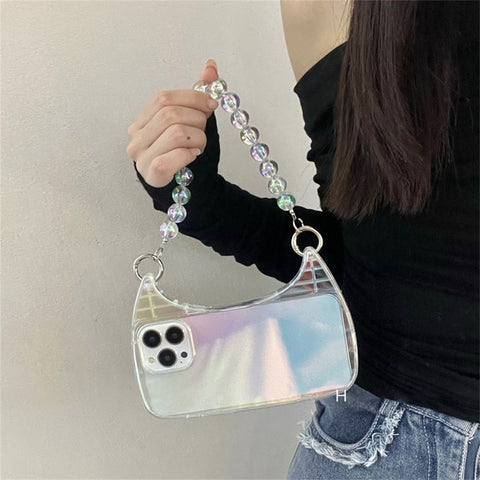 A woman's hand holding a phone case with an iridescent finish. The case shimmers in the light with shades of blue, purple, and pink. The phone case is held at an angle to show off its slim profile and the cutouts for the camera and buttons.